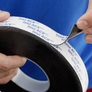 Un rouleau de ruban tesa® ACXplus 7063, une mousse acrylique double face haute performance et à haute adhésivité. Détail d’application.
